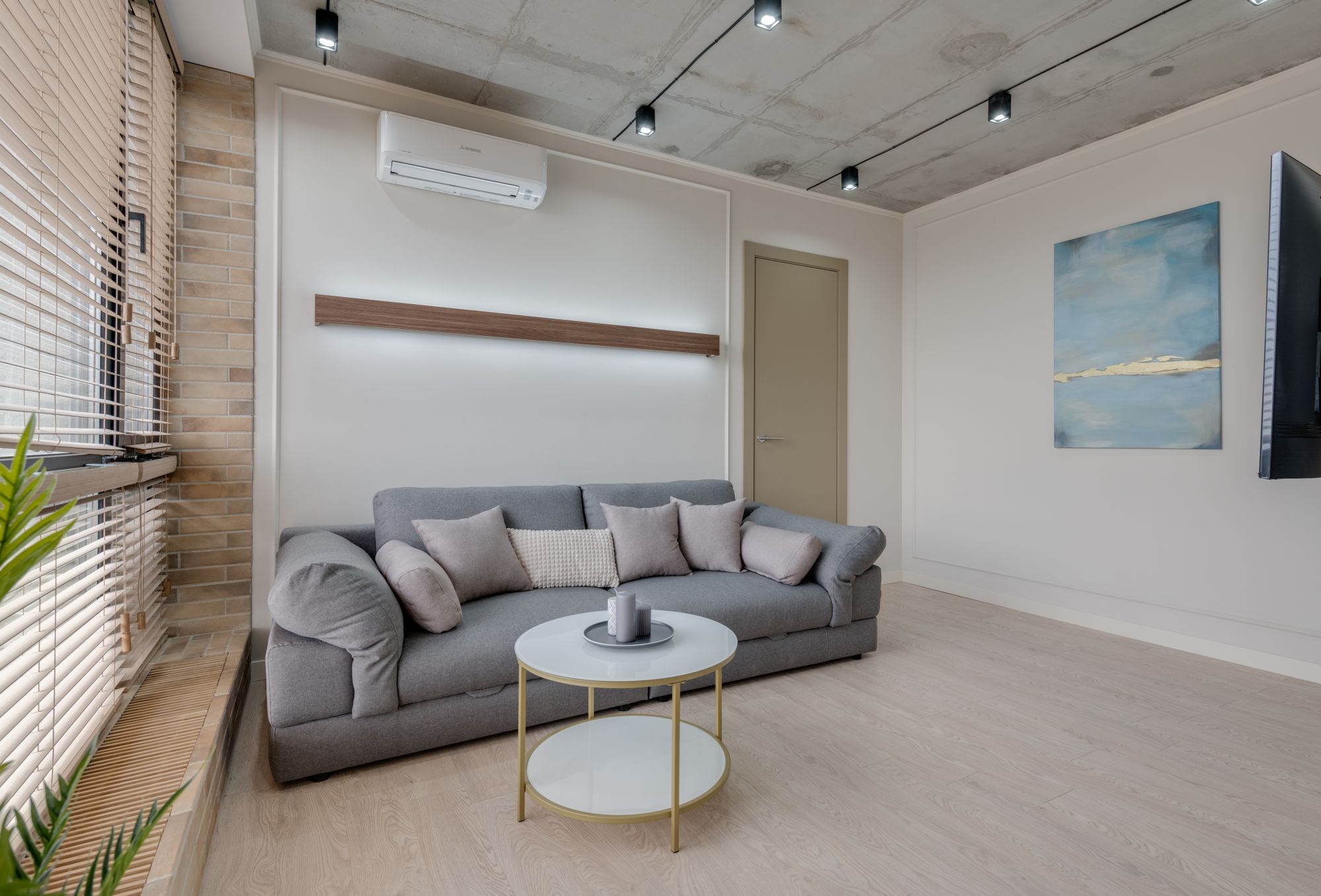 Stilvoll gestalteter Wohnraum mit Sofa und abstrakter Kunst